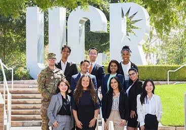 UCR School of Business students in front of UCR sign